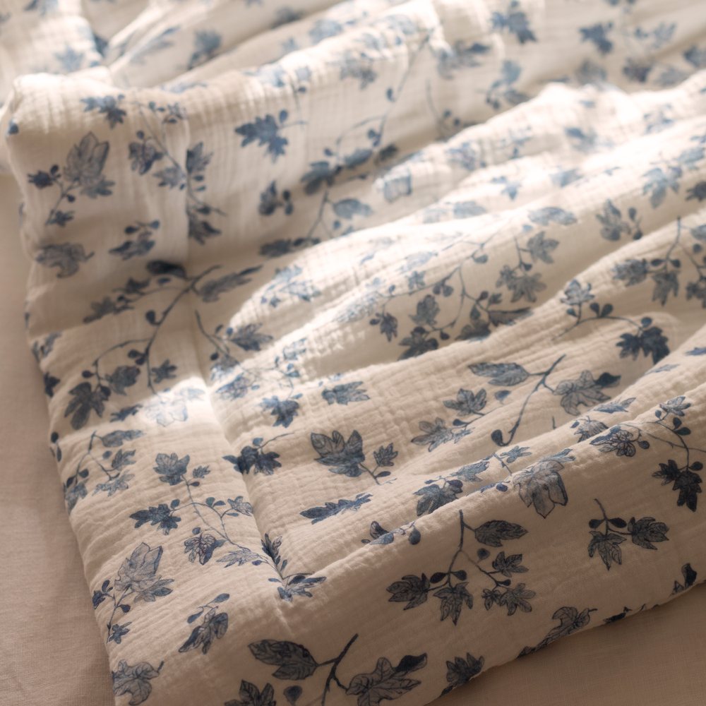 Fig muslin playmat folded over a linen chair